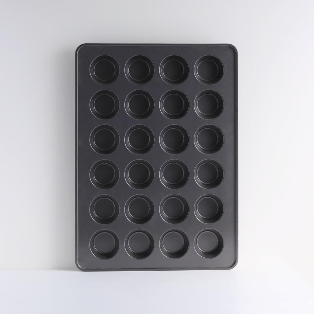 A 24-cup muffin pan sits on a white background.