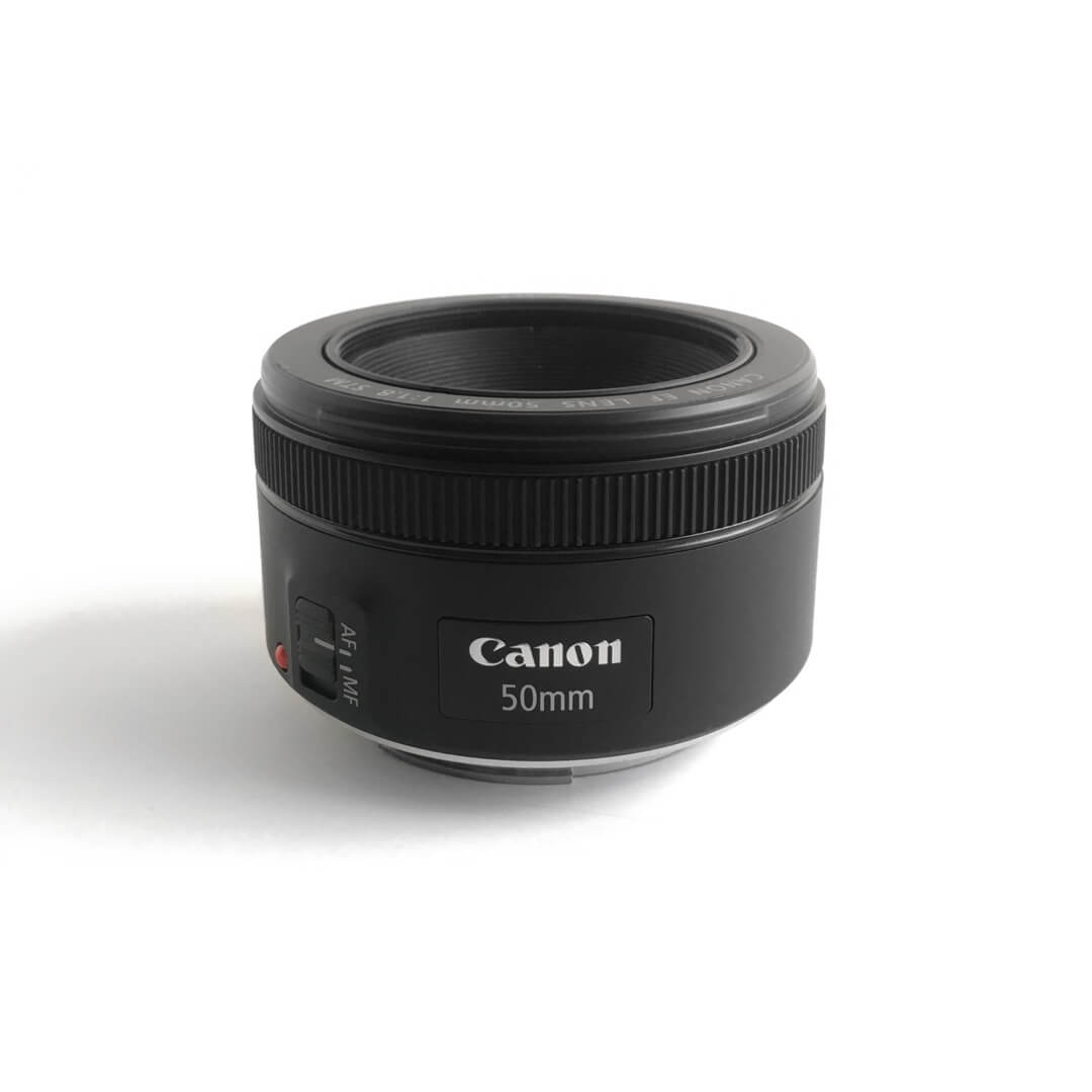 A Canon 50mm lens sits on a white background.