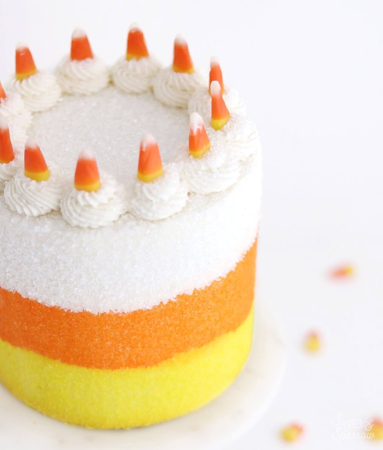 cake topped with candy corn by sugar and sparrow