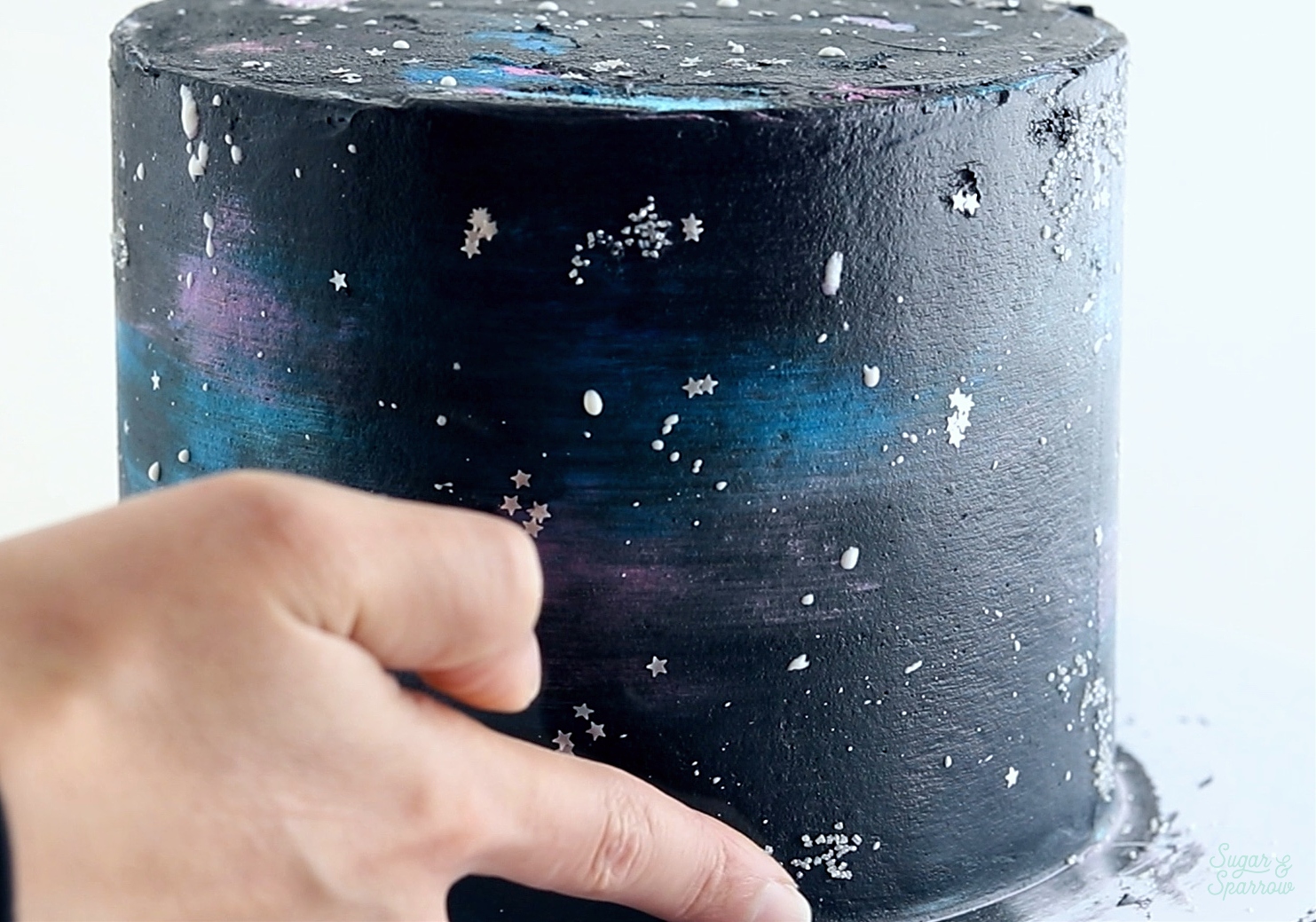 adding sprinkle stars to galaxy cake