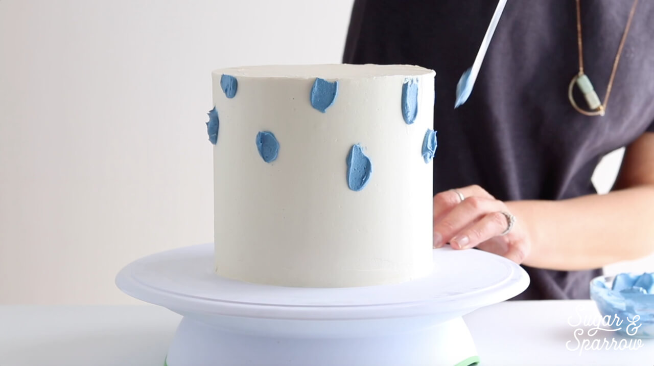 painting buttercream onto cake