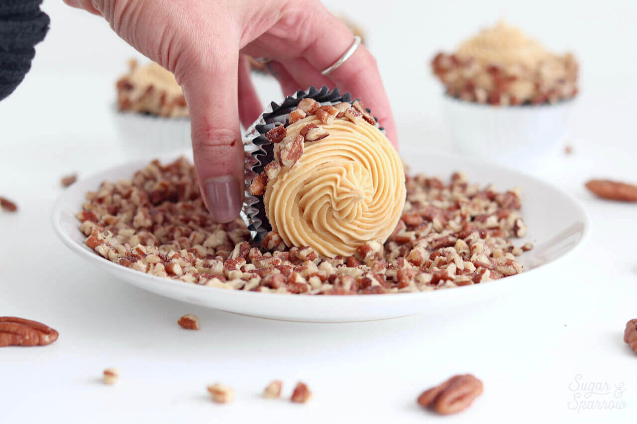 rolling cupcakes in chopped pecans