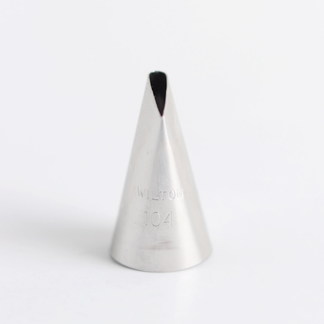 A metal Wilton icing tip (number 104) sits on a white background.